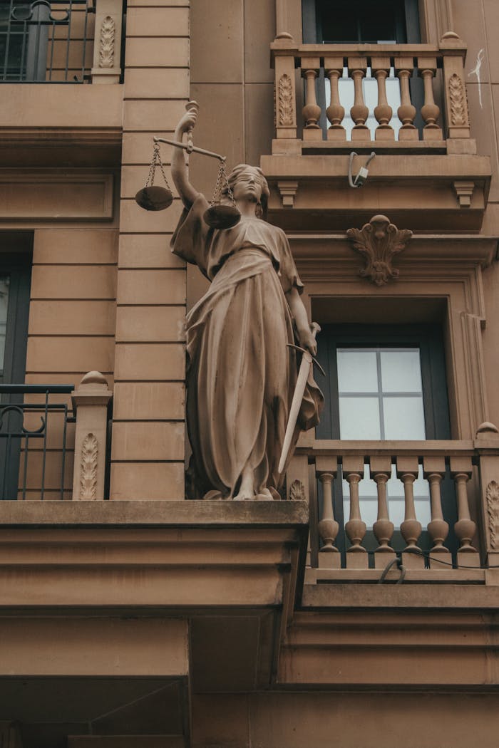 Home Elegant Justice statue with scales and sword on classic building facade, symbolizing law and fairness.
